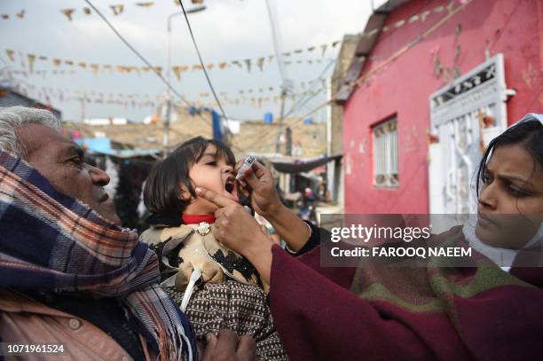 Pakistani Christian health worker administers polio vaccine drops to a child during a polio vaccination campaign in a Christian colony in Islamabad...