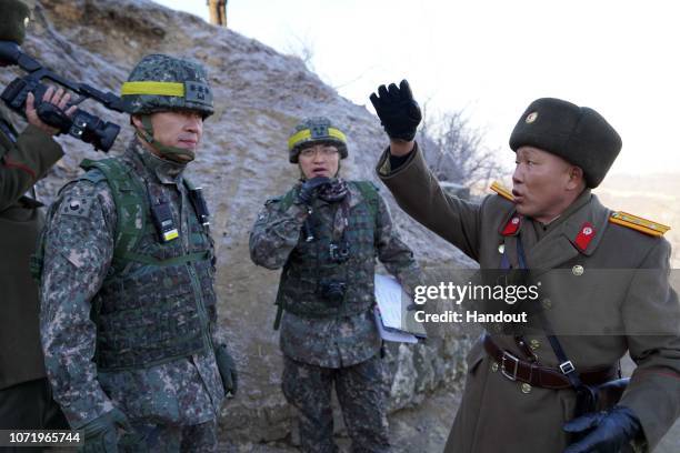 In this handout image provided by South Korean Defense Ministry, North Korean soldiers talk with a South Korean soldier during a mutual on-site...