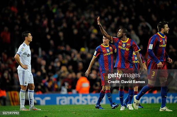 Cristiano Ronaldo of Real Madrid looks on as Eric Abidal of Barcelona gestures after Barcelona scored five goals againts Real Madrid, during the La...