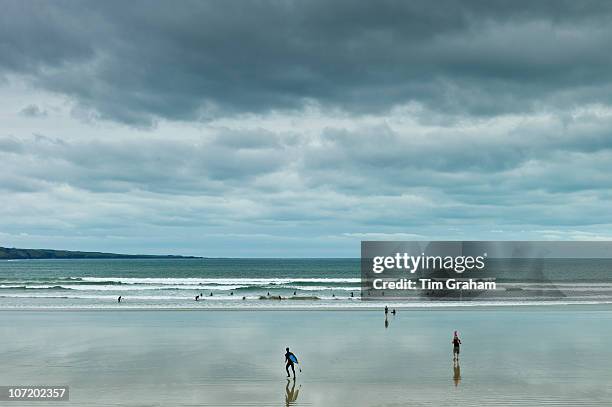 Waves, tide and surfers with surfboards at Lahinch - Lehinch - beach, County Clare, Ireland