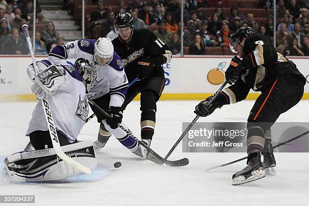 Goaltender Jonathan Quick of the Los Angeles Kings makes a save, as teammate Jack Johnson defends the puck from Corey Perry and Bobby Ryan of the...