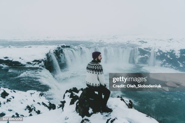 uomo che guarda la vista panoramica della cascata in inverno - dettifoss waterfall foto e immagini stock