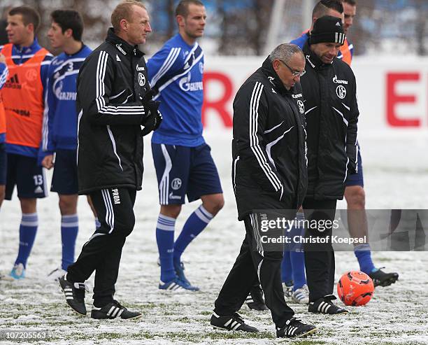 Assistant coach Seppo Eichkorn, head coach Felix Magath and assistant coach Bernd Hollerbach walk off the pithc after the FC Schalke training session...