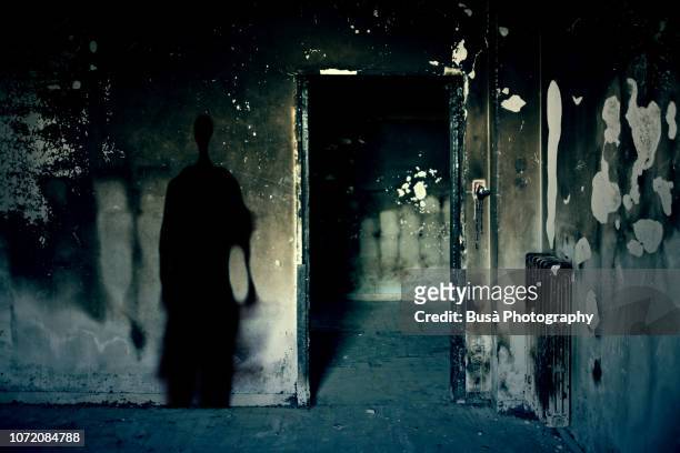 scary scene with spooky shadow in a dark room of an abandoned building - killing stock pictures, royalty-free photos & images
