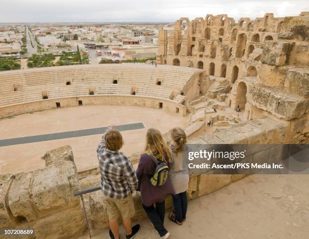 family looks over roman colliseum ruins - tunisian girls stock-fotos und bilder