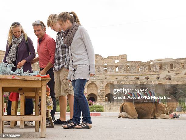 family shops for souvenirs beside roman colliseum - tunisia girl fotografías e imágenes de stock