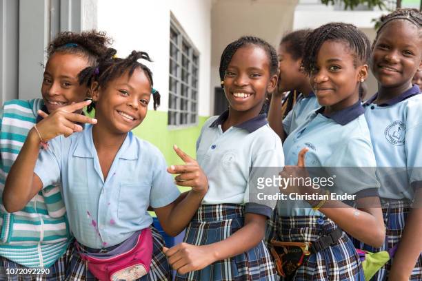 Cali, Colombia Schoolgirls in school uniform waving and posing in front of the camera during recess at El Retiro, a catholic school located in a...