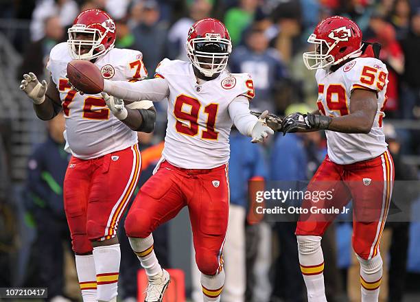 Linebacker Tamba Hali of the Kansas City Chiefs celebrates with Glenn Dorsey and Jovan Belcher after recovering a fumble on a sack of quarterback...