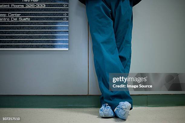 hospital surgeon wearing shoe protectors, low section - doctor scrubs stockfoto's en -beelden