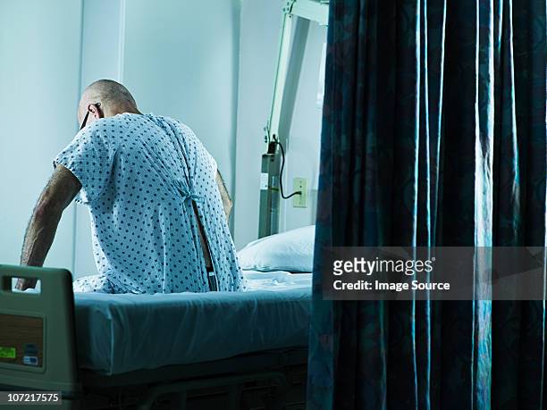 senior man sitting on hospital bed - men in bed 個照片及圖片檔
