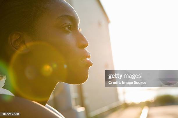 profile of a young woman in sunlight - determination face stock pictures, royalty-free photos & images