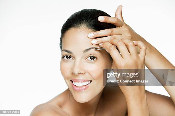 woman plucking her eyebrows - tweezing eyebrows stock pictures, royalty-free photos & images