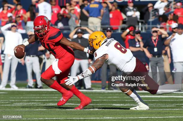 Quarterback Khalil Tate of the Arizona Wildcats scrambles away from linebacker Merlin Robertson of the Arizona State Sun Devils during the first half...