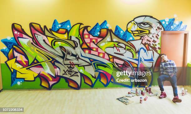 artist next to his graffiti - colorful mural stock pictures, royalty-free photos & images