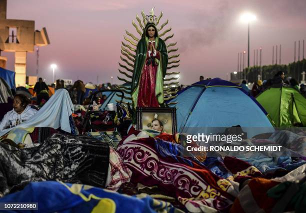 Pilgrims sleep near an image of the Virgin of Guadalupe, during the annual celebrations at the Basilica of Guadalupe in Mexico City, on December 12,...