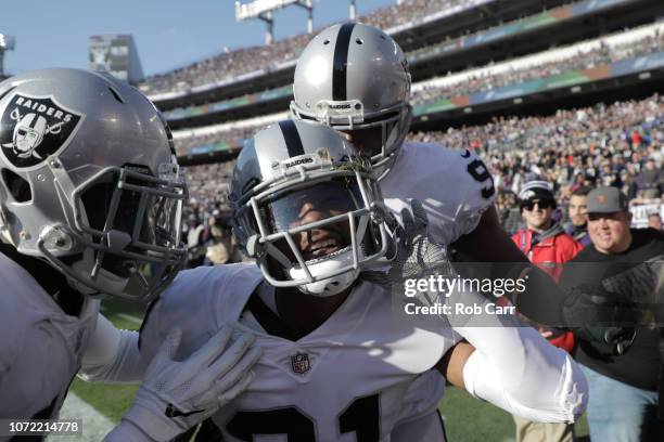 Strong Safety Marcus Gilchrist of the Oakland Raiders celebrates with teammates after an interception in the second quarter against the Baltimore...