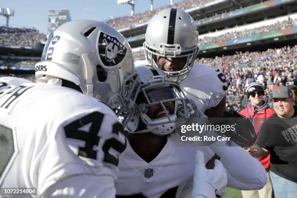 Strong Safety Marcus Gilchrist of the Oakland Raiders celebrates with teammates after an interception in the second quarter against the Baltimore...