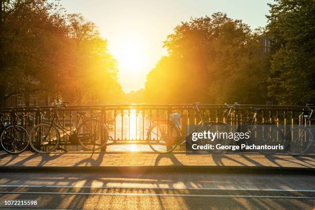 bridge with bicycles at sunset - amsterdam autumn stock pictures, royalty-free photos & images