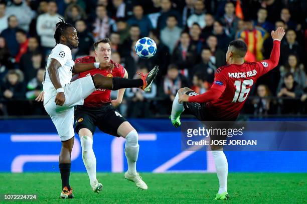 Valencia's Belgian forward Michy Batshuayi challenges Manchester United's English defender Phil Jones and Manchester United's Argentinian defender...