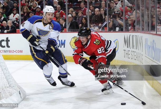 Tomas Kopecky of the Chicago Blackhawks gets in position to grab the puck as Eric Brewer of the St. Louis Blues approaches from the side on November...