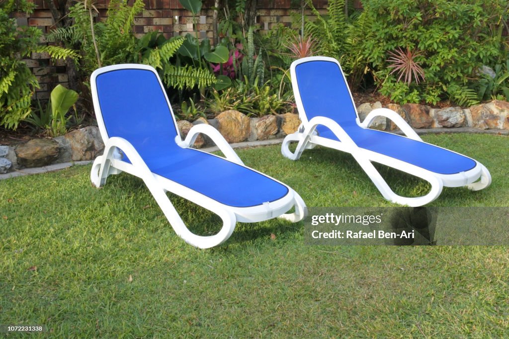 Two Sun Beds on a Green Grass
