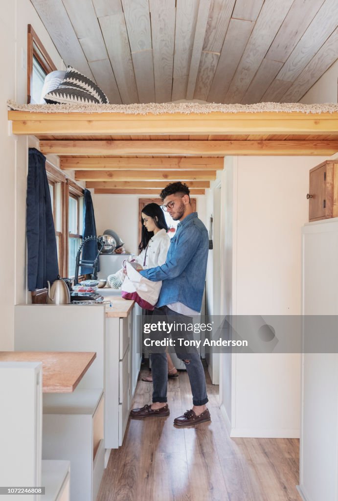 Young couple unpacking shopping in their tiny house