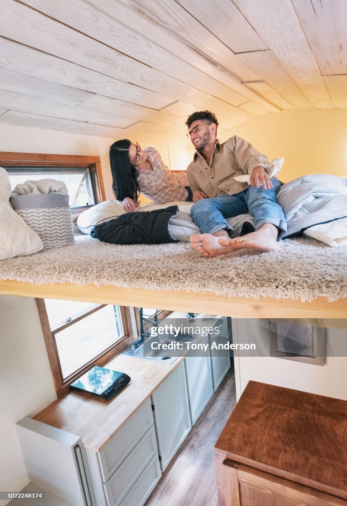Young couple in bedroom loft of tiny house