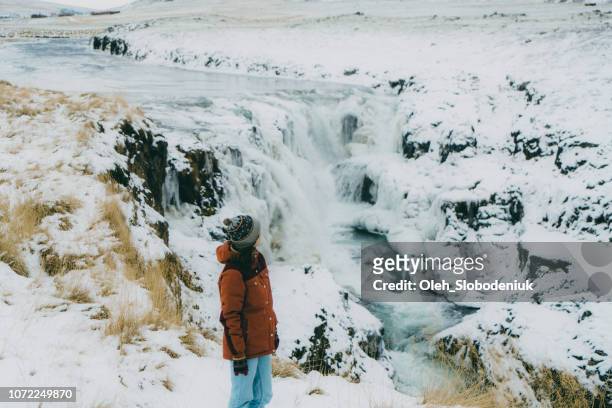 woman looking at  waterfall in winter - dettifoss waterfall stock pictures, royalty-free photos & images
