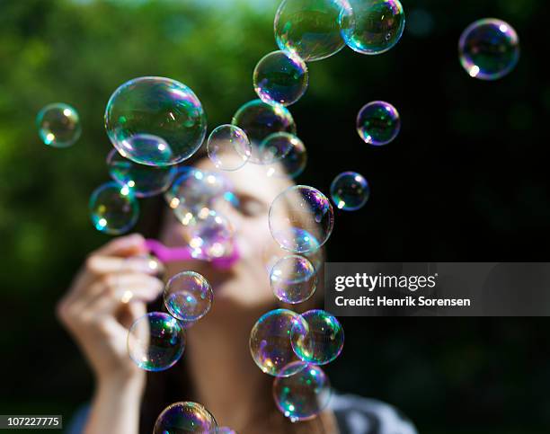 girl blowing soapbubbles - bellenblaas stockfoto's en -beelden