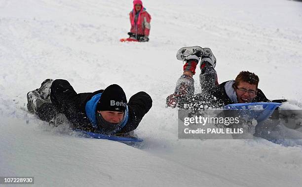 People sledge down a hill in Ladderedge Country Park in Leek, north-west England, on December 1, 2010. Britain's transport links with the rest of the...