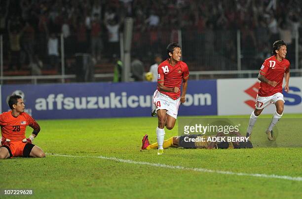Malaysian goalkeeper Khairul Fahmi looks on as Indonesian player Arif Suyono and teammate Irfan Haarys Bachdim celebrate a goal during a...