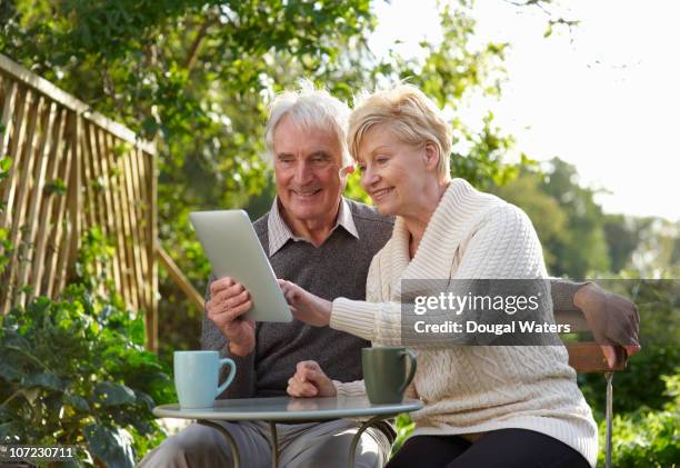 couple using digital tablet in garden. - retirement planning stock pictures, royalty-free photos & images