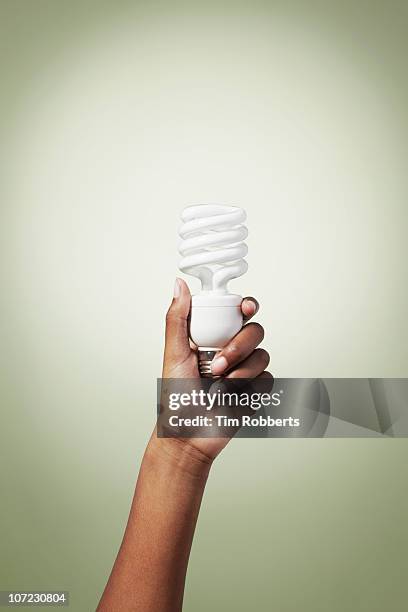 young woman holding energy efficient light bulb. - energy efficient lightbulb bildbanksfoton och bilder