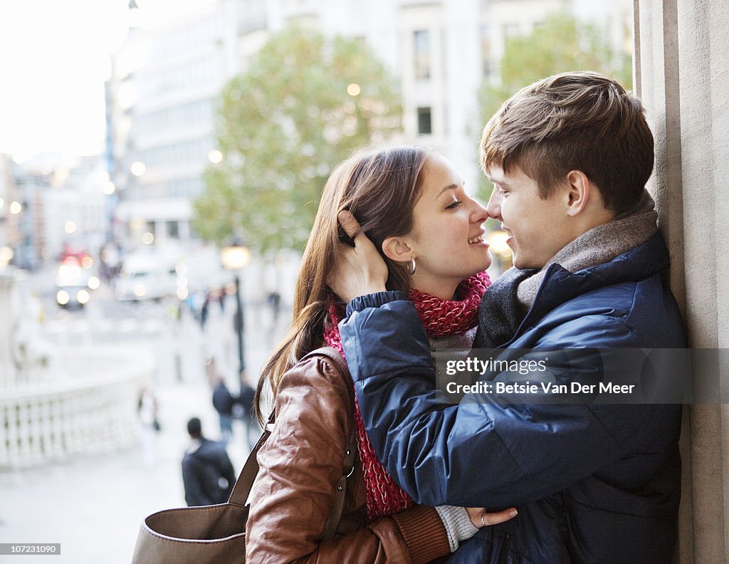 Couple embracing with cityview in background.