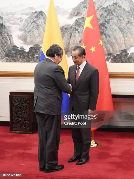 Colombian Foreign Minister Carlos Holmes Trujillo shakes hands with Chinese Foreign Minister Wang Yi before a meeting in the Diaoyutai State...