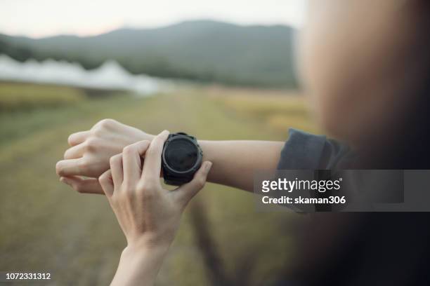 asian young traveller use gps watch at countryside and mountain - modern compass stockfoto's en -beelden