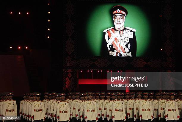 Omani soldiers parade under a picture of Omani ruler Sultan Qaboos bin Said on the third day of celebrations marking 40 years since he took the...
