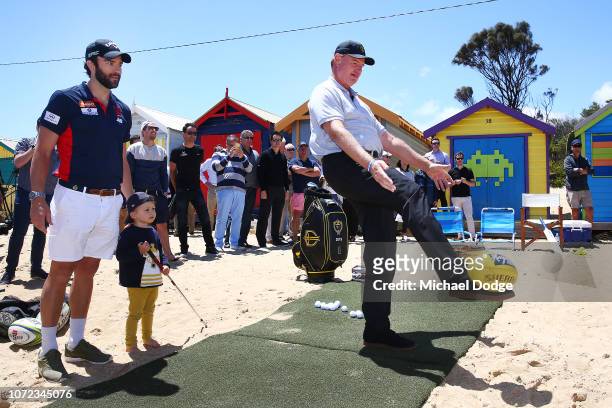 Golfer Ernie Els of South Africa, watched by Melbourne Demons' Jordan Lewis, kick an Australian Rules football at a target during The Big Easy's BBQ...