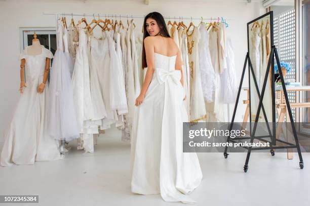 asian girls try out wedding dresses . - wedding dress on hanger stock pictures, royalty-free photos & images