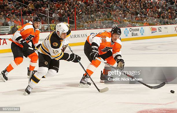 Darroll Powe of the Philadelphia Flyers skates after the puck with Nathan Horton of the Boston Bruins at the Wells Fargo Center on December 1, 2010...