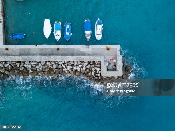 small boats anchored by the concrete pier from above - safe harbor stock pictures, royalty-free photos & images