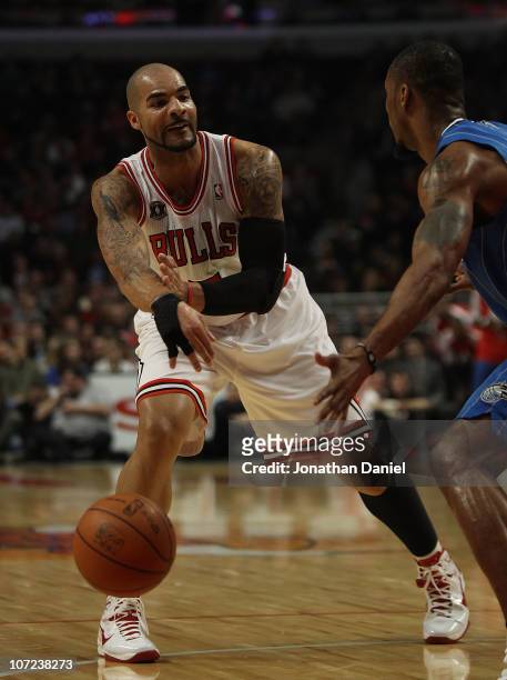 Carlos Boozer of the Chicago Bulls passes the ball around Rashard Lewis of the Orlando Magic in his first start of the season at the United Center on...