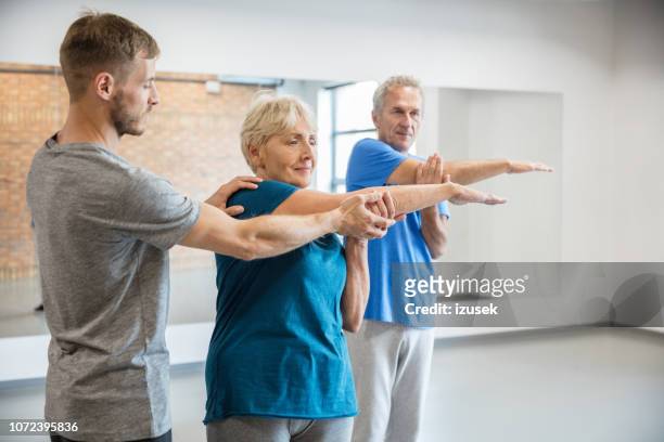 senior people exercising with trainer at rehab club - drug rehab stock pictures, royalty-free photos & images
