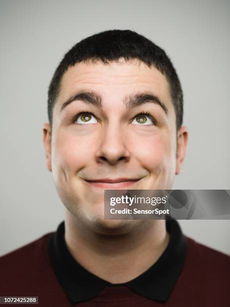 portrait of a happy young caucasian man looking up - mouth smirk stock pictures, royalty-free photos & images
