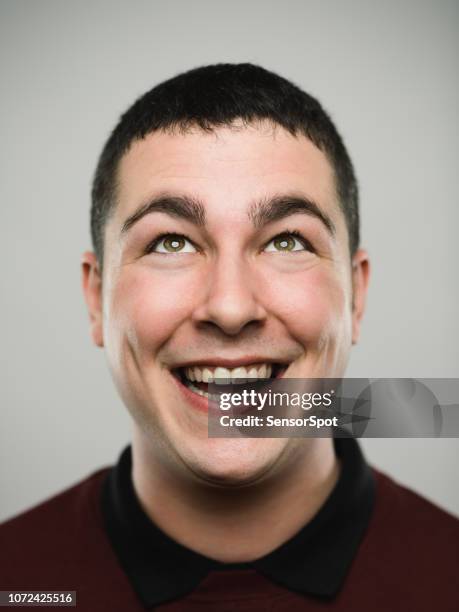 portrait of an excited young caucasian man looking up - mouth smirk stock pictures, royalty-free photos & images