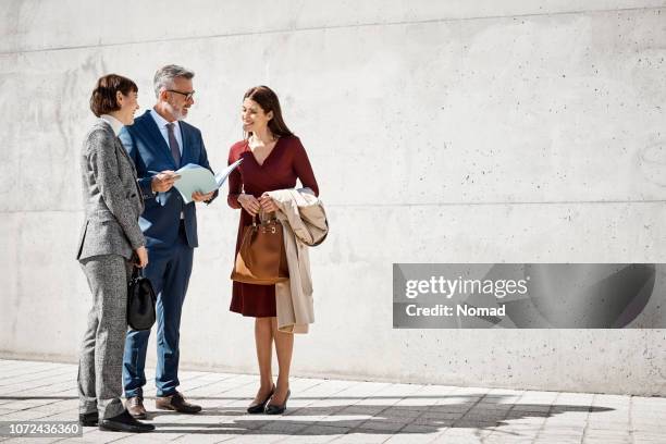 leidinggevenden bespreken over documenten op straat - city map stockfoto's en -beelden