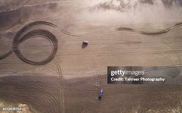 jeeps on beach while tire tracks are seen everywhere - autoreifen natur stock-fotos und bilder