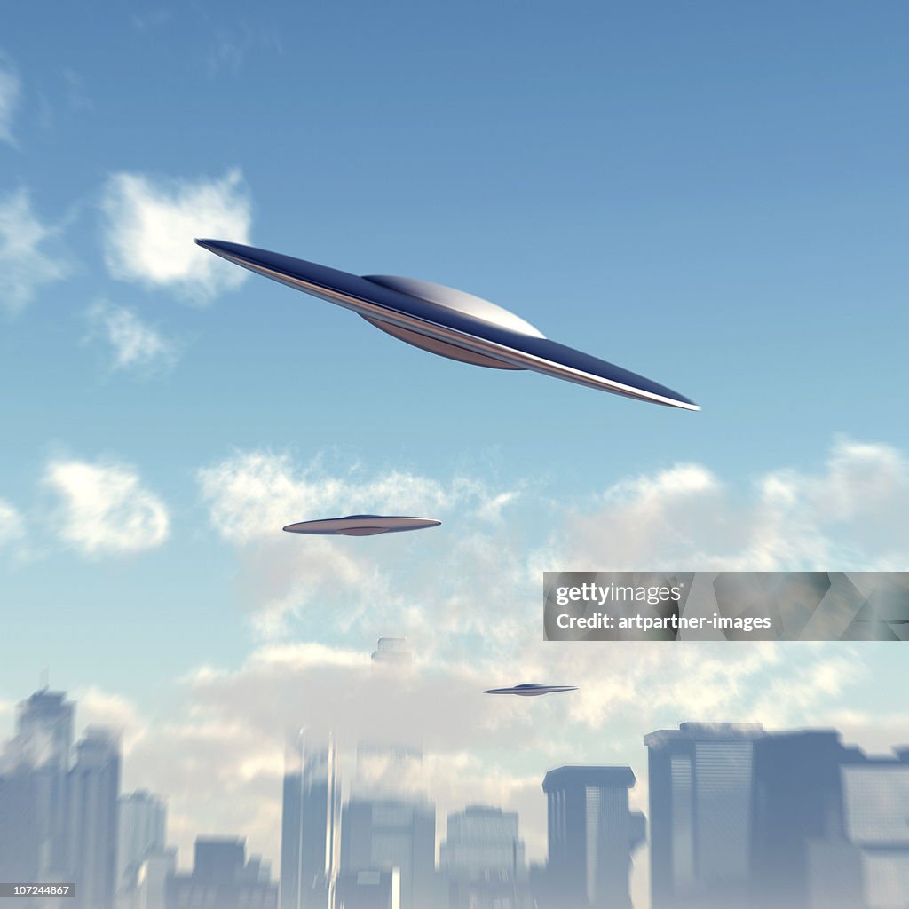 Ufos flying above a Big City Skyline