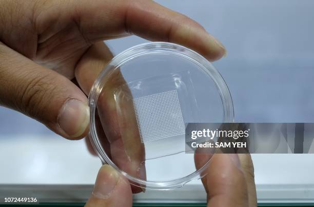 Man displays a piece of microneedle patch by the Win Coat Corporation at the 2018 Future Tech Expo in Taipei on December 13, 2018. - More then 100...