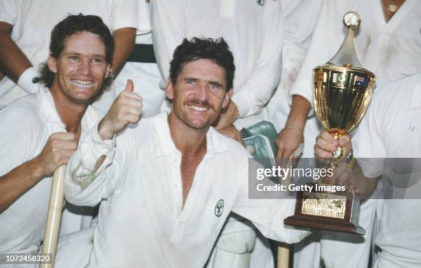 Australia captain Allan Border holds the trophy as Dean Jones looks on after Australia had beaten England by 7 runs to win the 1987 Cricket World Cup...